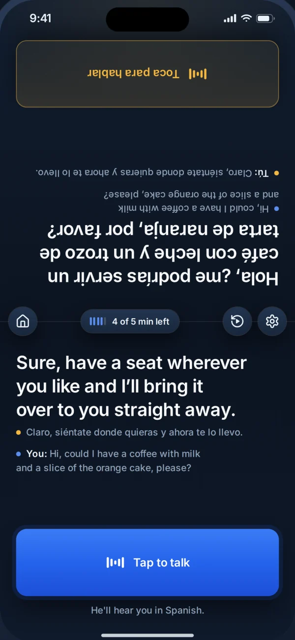 The LingoVoice app on one phone between two people. The top half faces the Spanish speaker, upside down for you. The bottom half reads: Sure, have a seat wherever you like and I'll bring it over to you straight away. Below it, a Tap to talk button and the line: He'll hear you in Spanish.